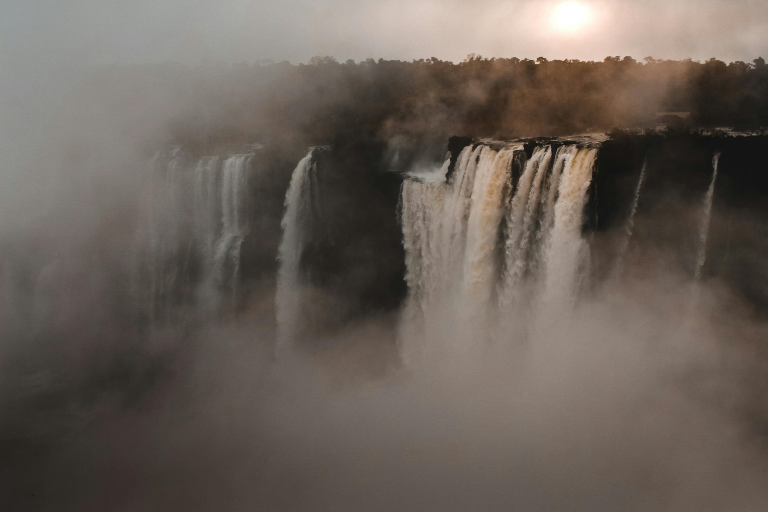 A stunning view of a grand waterfall enveloped by mist, showcasing nature's beauty.